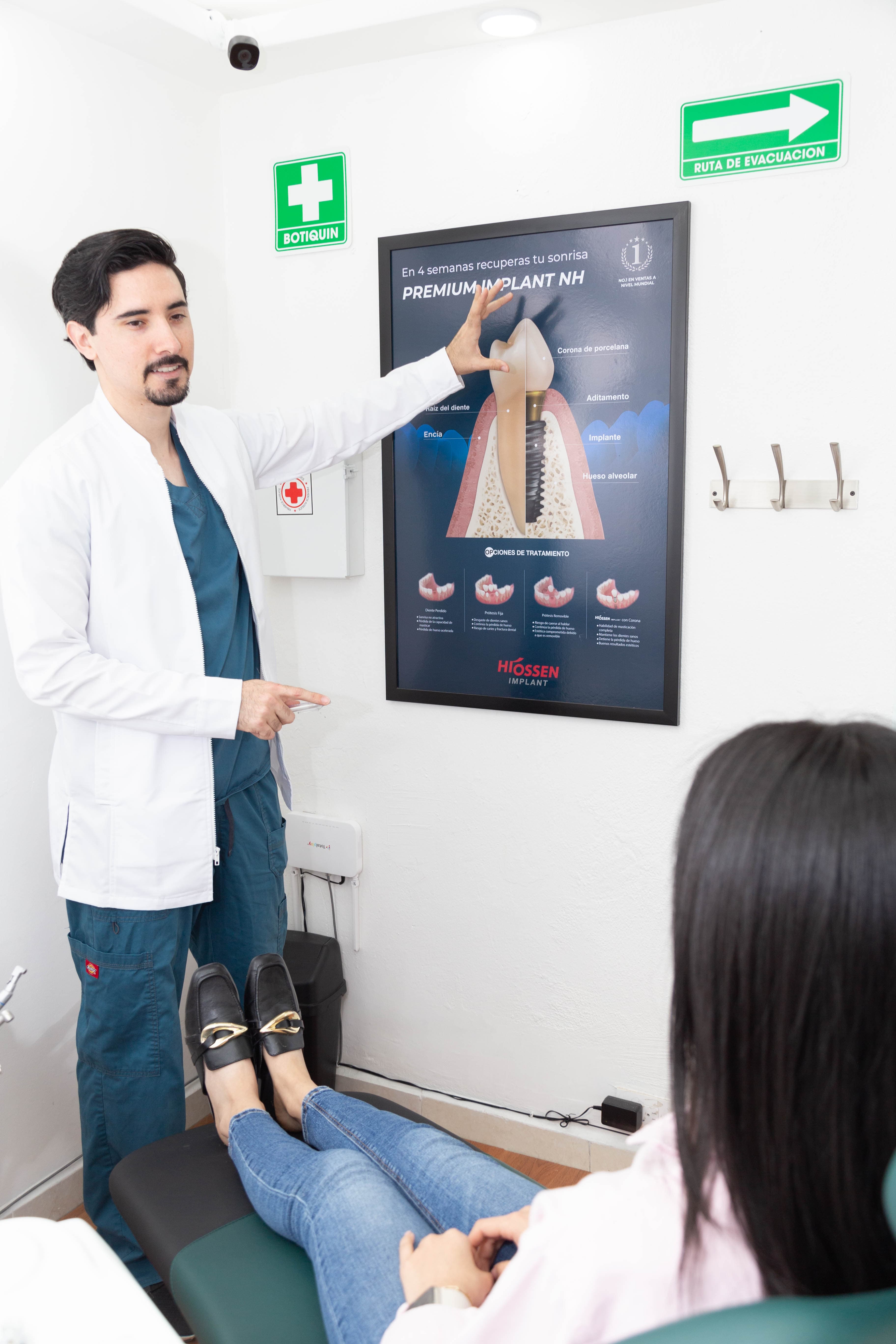 Dr. Joel explicando el proceso de un implante dental con diagrama