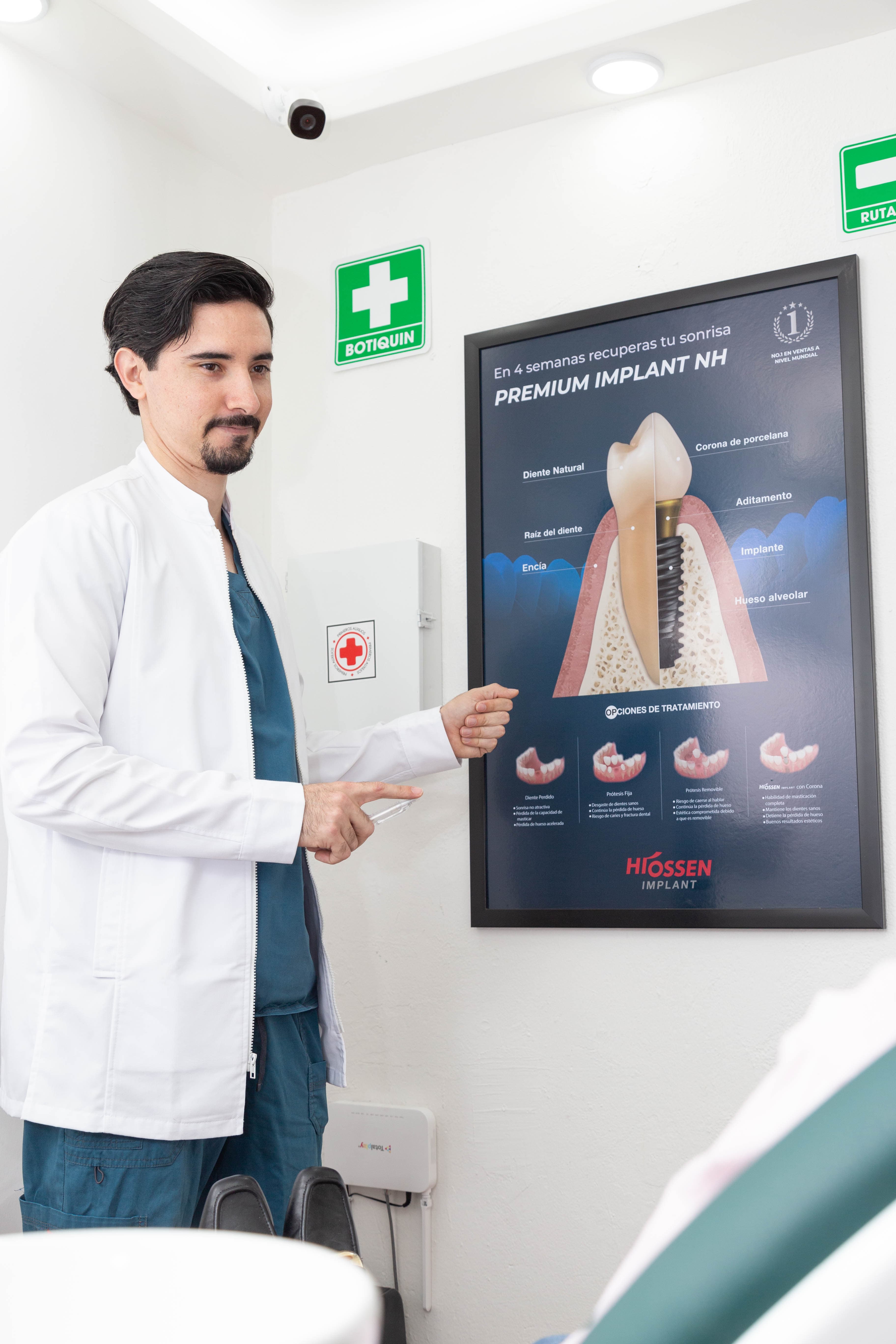 Dr. Joel mostrando poster educativo sobre implantes Premium