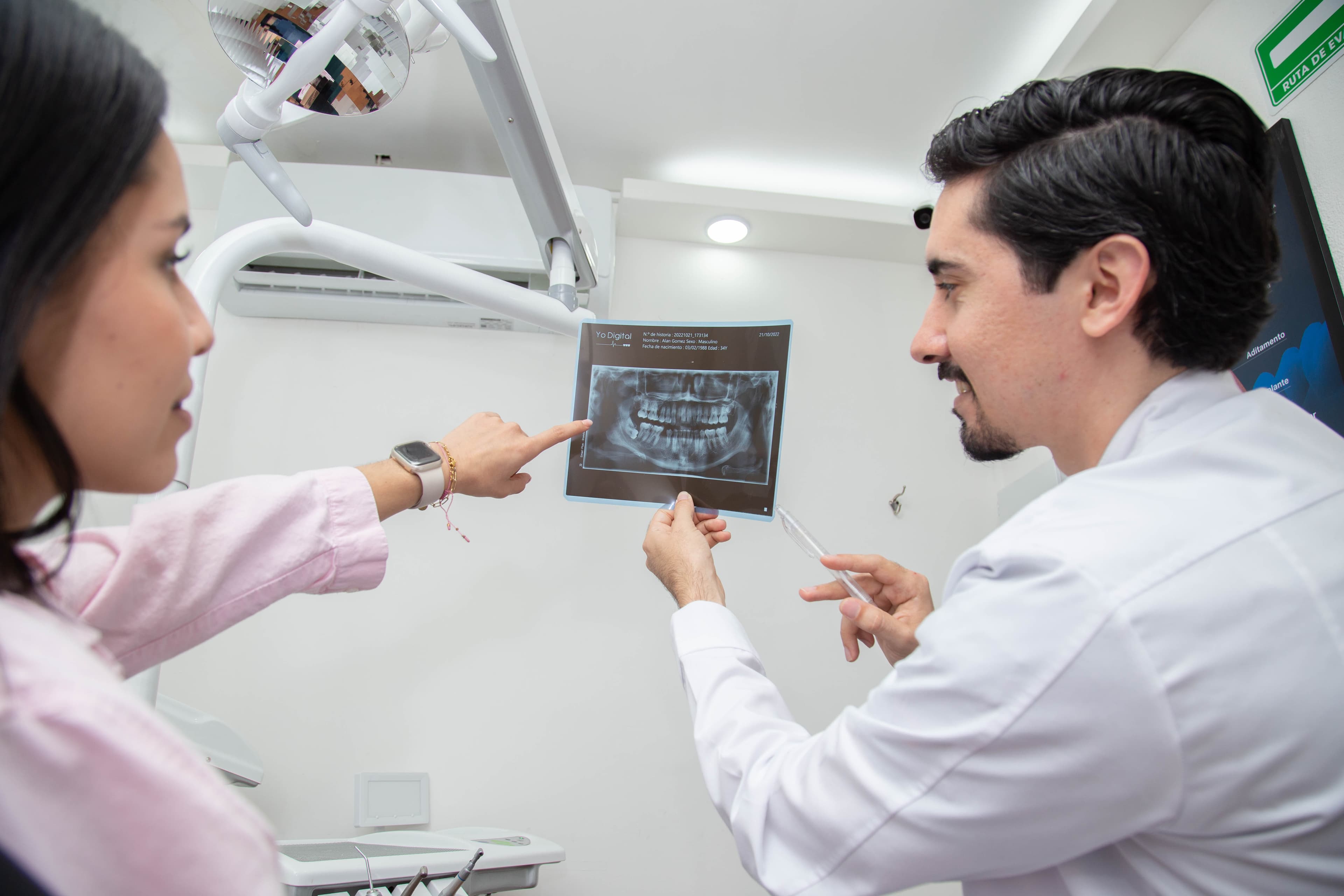 Dr. Joel y paciente observando juntos una radiografía panorámica