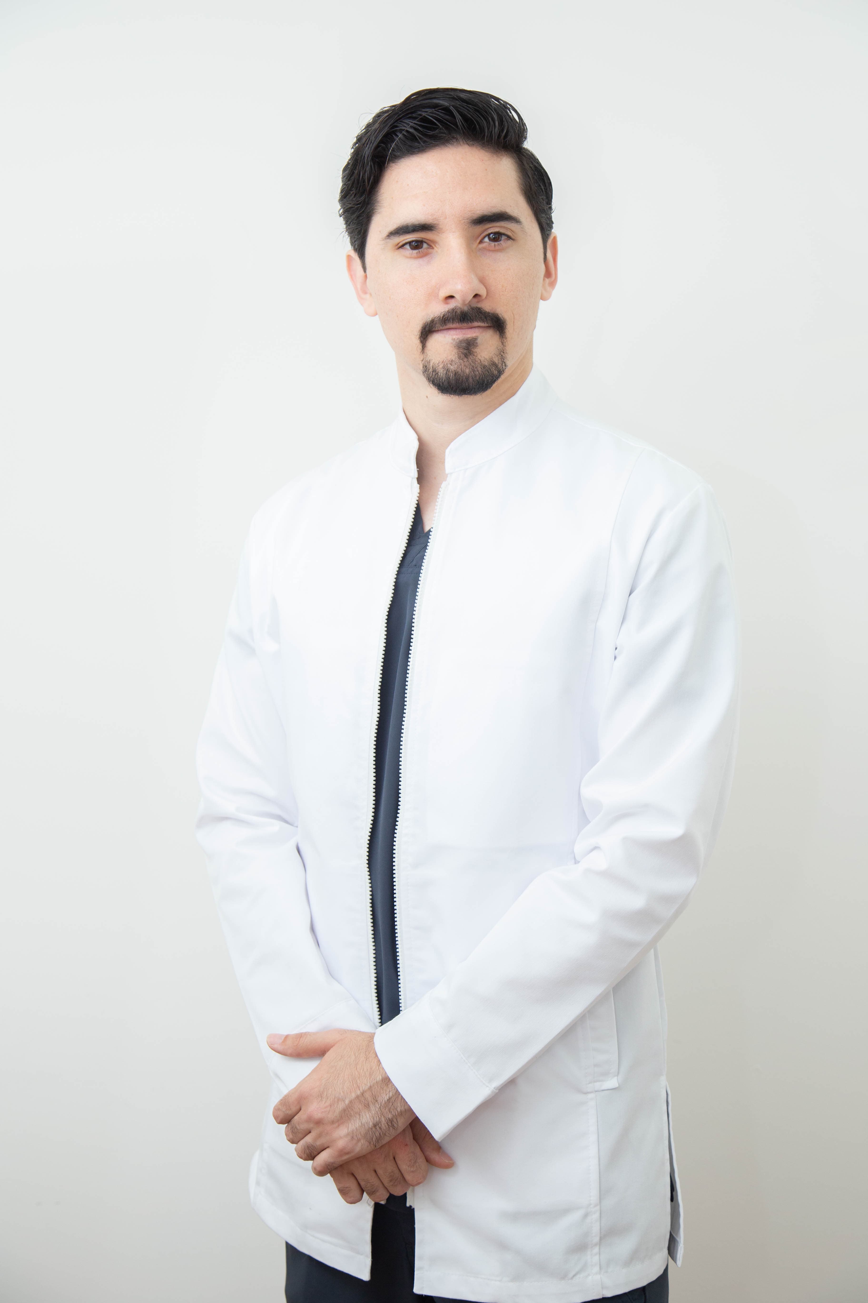 Dr. Joel Méndez Monge con bata blanca médica