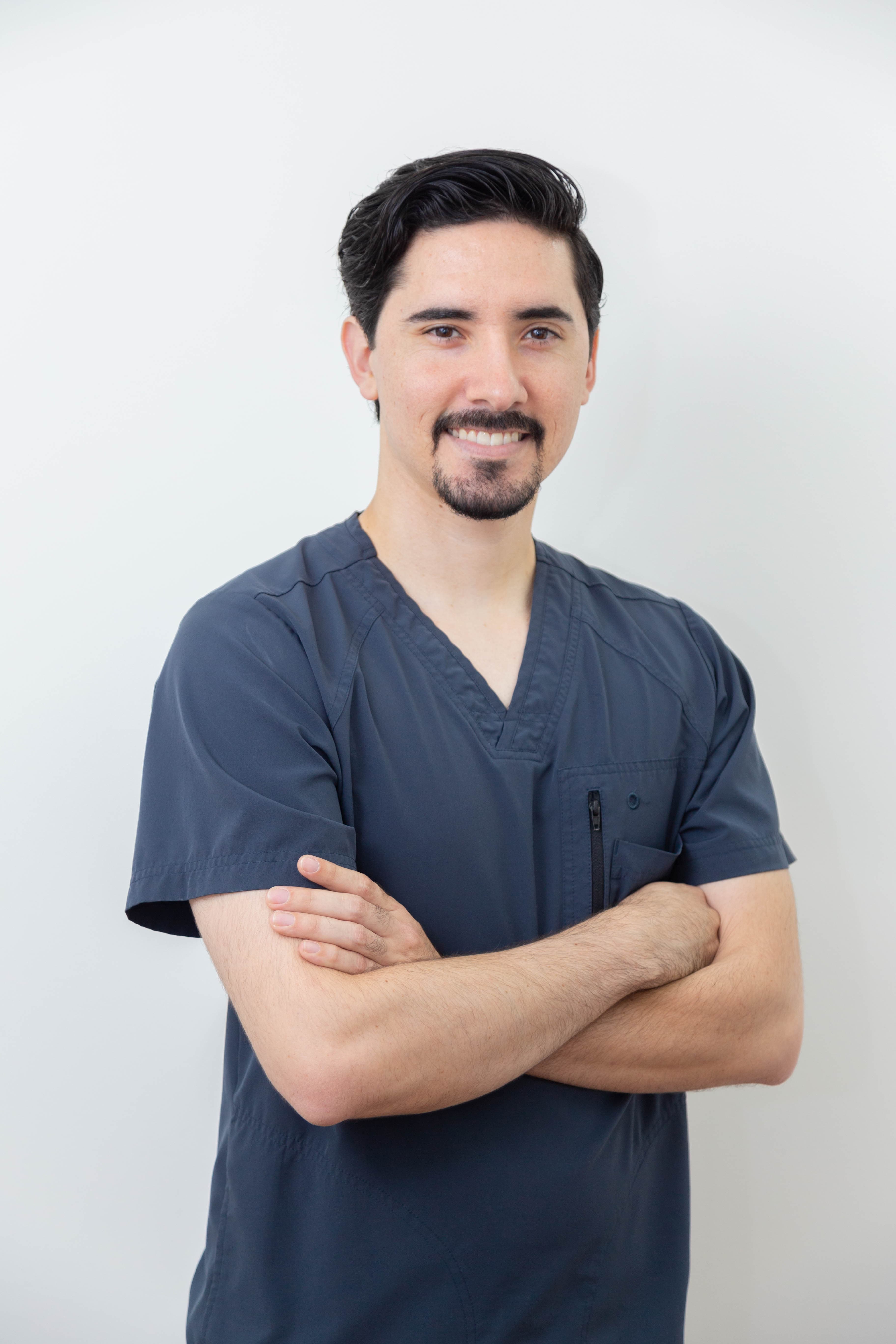 Dr. Joel Méndez Monge con scrubs azul marino