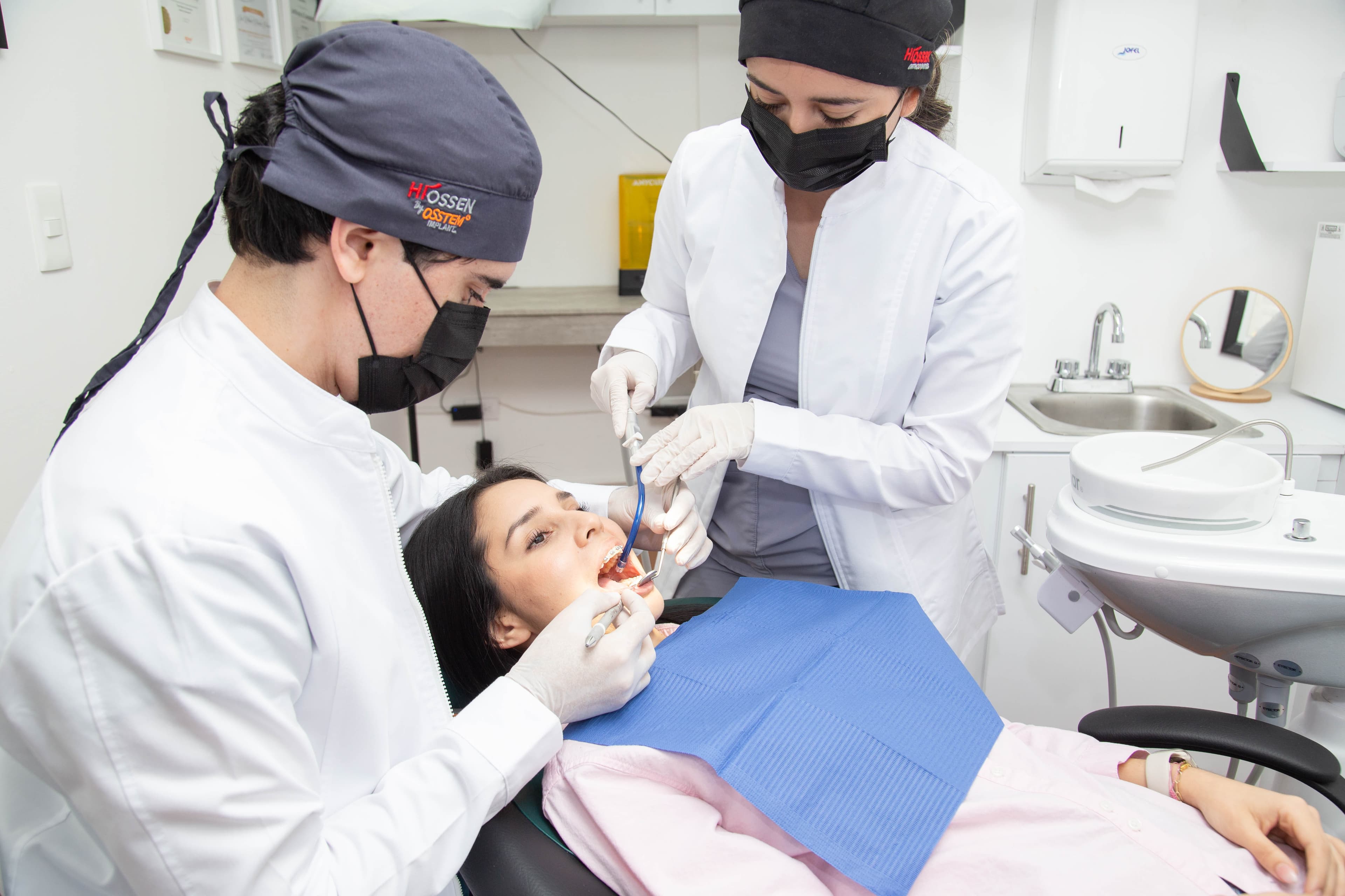 Dr. Joel y asistente realizando un procedimiento dental